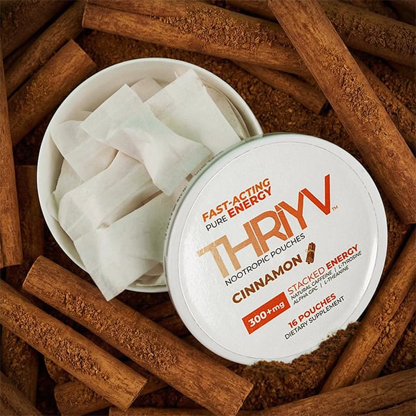 THRYV Cinnamon nootropic pouches with packaging surrounded by cinnamon sticks